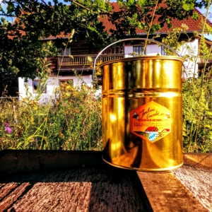 Ein frisch gefülltes Honigeimerchen aus goldenem Weissblech.