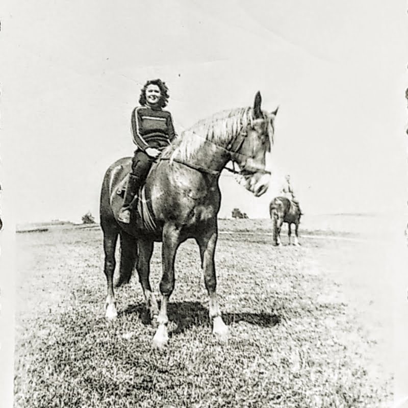 Frau auf Pferd in schwarzweisser alter Aufnahme.