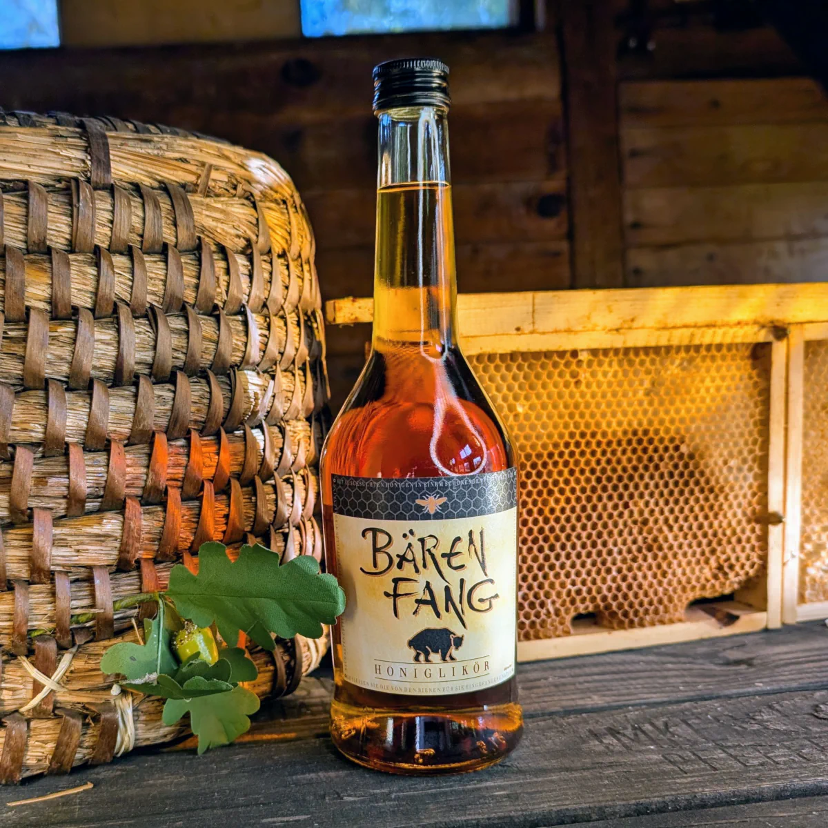 Zu den Hof Spezialitäten wie Honigwein und Likör zählt beispielhaft der ostpreussische Bärenfang, der hier im Bienenhaus vor einer Honigwabe und einem Bienenkorb steht.